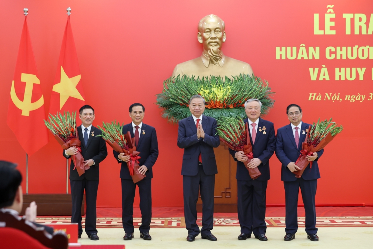 លោកអគ្គលេខាបក្ស តូ ឡឹម ប្រគល់ផ្កាអបអរសាទរថ្នាក់ដឹកនាំបក្ស និងរដ្ឋដែលទទួលបានផ្លាកសញ្ញាសម្គាល់អាយុបក្ស។ (រូបថត៖ VGP/Nhat Bac)