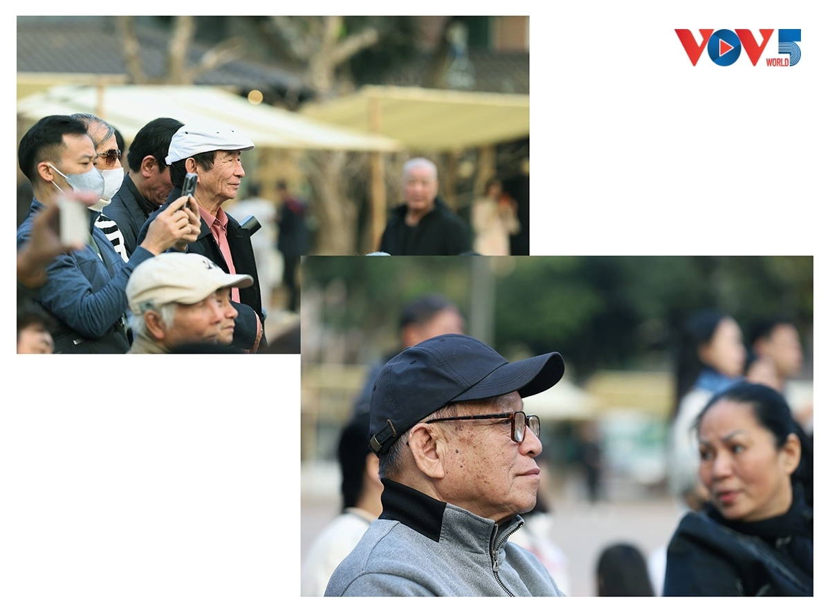 ຜູ້ຊົມພວມຕັ້ງໃຈຕິດຕາມລາຍການສະແດງ, ຫຼາຍຄົນກໍ່ບັນທຶກລາຍການດ້ວຍໂທລະສັບມືຖື.